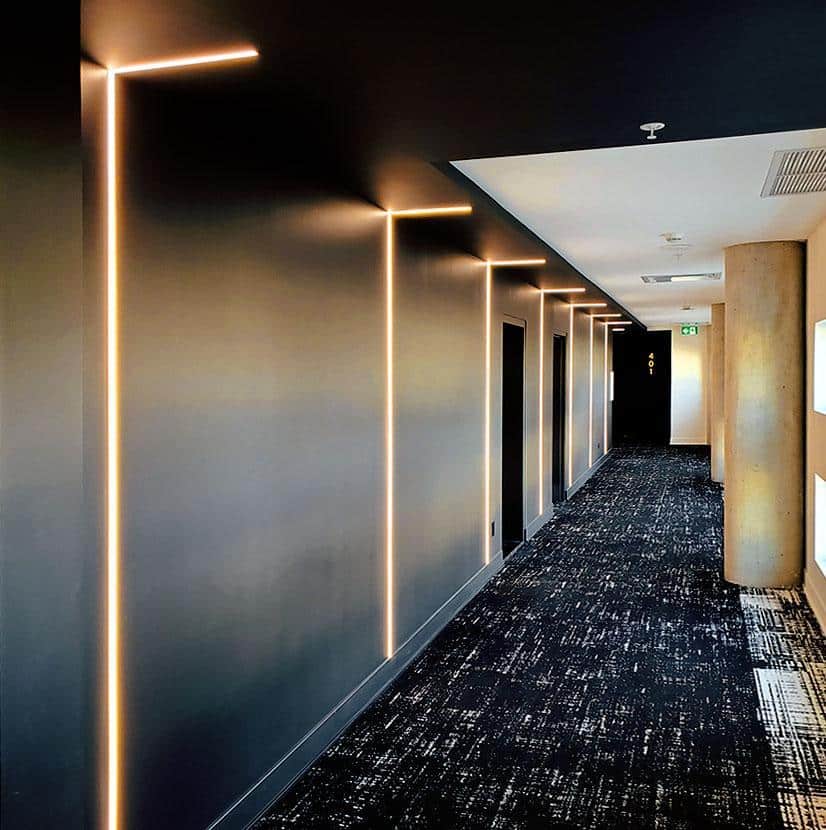 An office hall with recessed LED linear lighting.