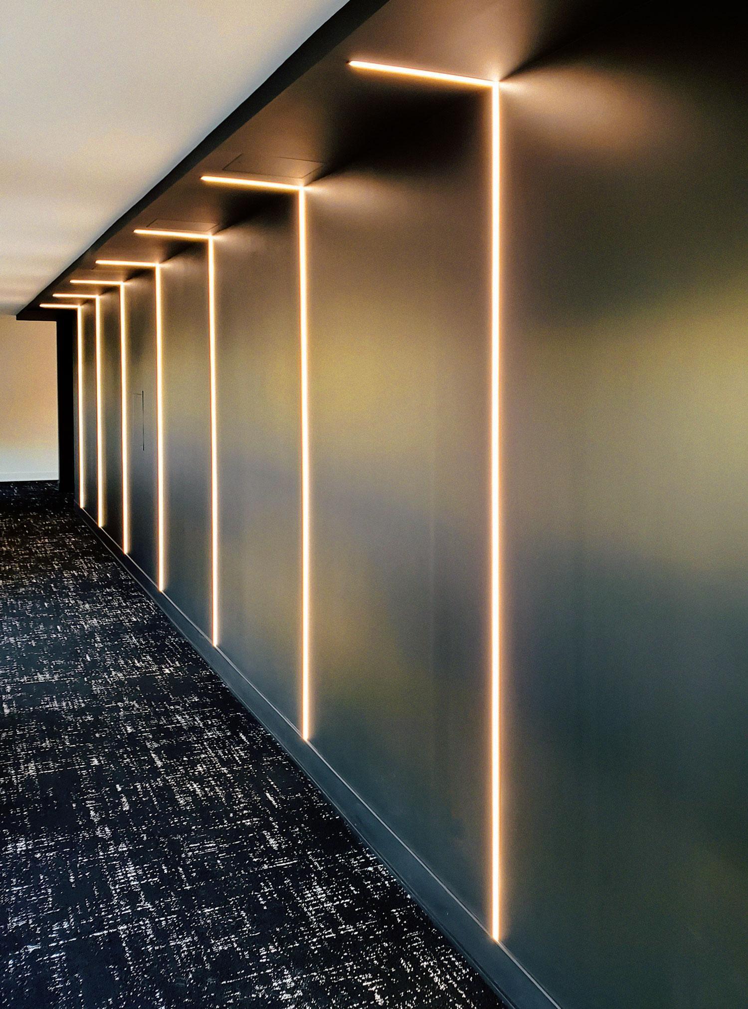 Un hall de bureau avec un éclairage linéaire DEL encastré.